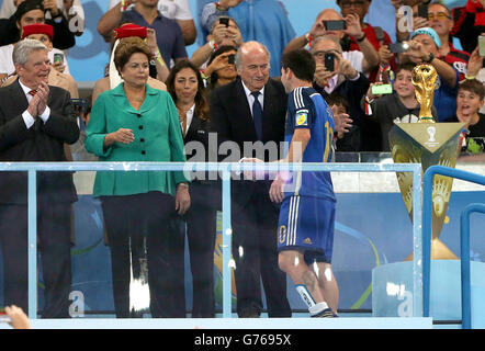 Football - coupe du monde de la FIFA 2014 - finale - Allemagne / Argentine - Estadio do Maracana.Lionel Messi, en Argentine, semble abattu alors qu'il reçoit le prix du Golden ball du président de la FIFA, Sepp Blatter Banque D'Images