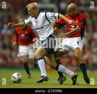 Juan Veron, de Manchester United, lance un défi par Frandsen de Bolton Wanderers pour le ballon lors du match Barclaycard Premiership à Old Trafford, Manchester. Banque D'Images