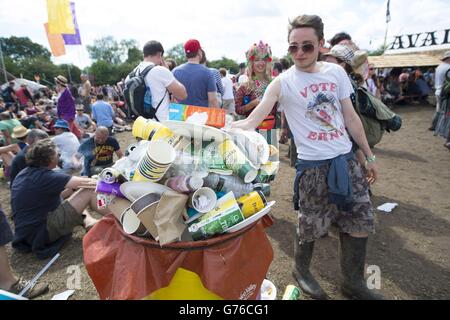 Les festivalgoers utilisent des bacs de recyclage au Glastonbury Festival, à la ferme de la ville de Kalimary, dans le Somerset.Tous les déchets sur place sont triés en groupes de recyclage par des bénévoles travaillant par quarts de 5 heures, selon un processus qui prendra jusqu'à trois semaines pour nettoyer l'ensemble de la ferme. Banque D'Images