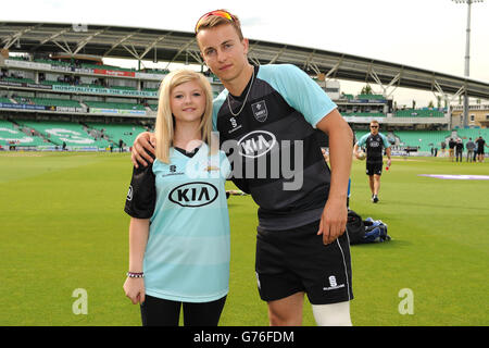 Cricket - NatWest T20 Blast - Division Sud - Surrey / Kent Spitfires - Kia Oval.Thomas Curran de Surrey avec la mascotte du jour du match Rebecca Garrard (à gauche) Banque D'Images