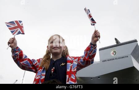 Amy Roslender, 6 ans, alors que la reine Elizabeth II a officiellement nommé le nouveau porte-avions de la Royal Navy HMS Queen Elizabeth lors d'une visite au chantier naval de Rosyth en Écosse. Banque D'Images