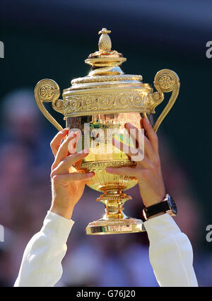 Le Novak Djokovic de Serbie lève le trophée alors qu'il célèbre la défaite de Roger Federer de la Suisse à la finale des hommes lors du 14 e jour des championnats de Wimbledon au All England Lawn tennis and Croquet Club, Wimbledon. Banque D'Images