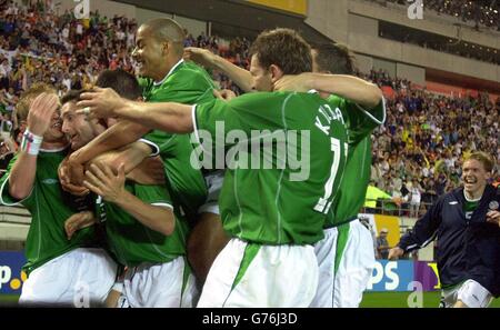 L'attaquant de la République d'Irlande robbie Keane est pris par des copains irlandais qui ont égalisateur de dernière minute contre l'Allemagne lors de la coupe du monde, premier tour, match de groupe E au stade Kashima. Ibaraki, Japon. Banque D'Images