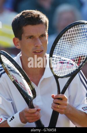 Tim Henman, le numéro un des meilleurs joueurs de tennis de Grande-Bretagne, choisit soigneusement une nouvelle raquette lors de son match contre Scott Draper, d'Australie, sur le court central de Wimbledon. Banque D'Images