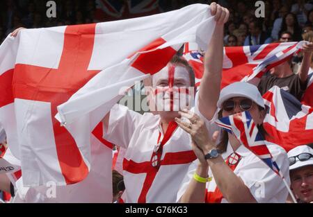 Stuart McRill, de Manchester, et Julia John, d'Ipswich, applaudissent la star britannique du tennis masculin Tim Henman lors de son match contre Wayne Ferreira, d'Afrique du Sud, sur le Centre court de Wimbledon. Le gagnant passe aux quarts de finale. Banque D'Images