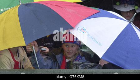 POUR , PAS D'UTILISATION COMMERCIALE. Les fans de tennis sur le court 1 à Wimbledon se couvrent d'une douche à la pluie soudaine lors du match entre la star britannique de tennis numéro un Tim Henman et le suisse Michel Kratochvil. *... dans le quatrième tour sur court One à Wimbledon. Banque D'Images