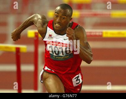 Colin Jackson du pays de Galles se plie en vain pour que la ligne soit battue en deuxième position lors de la finale des 110 mètres haies aux Jeux du Commonwealth à Manchester. Banque D'Images