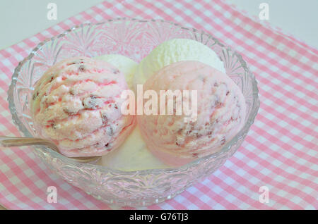 Boules de glace à la Fraise et crème glacée à la vanille dans un bol sur une serviette à carreaux blancs et roses, macro, Close up Banque D'Images