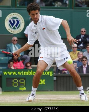 Andre sa du Brésil en action lors de son match contre Tim Henman, le meilleur joueur de Grande-Bretagne en quart de finale sur Center court à Wimbledon. Des averses de pluie intermittentes ont interrompu le jeu après que Henman a gagné le premier ensemble 6:3. Banque D'Images