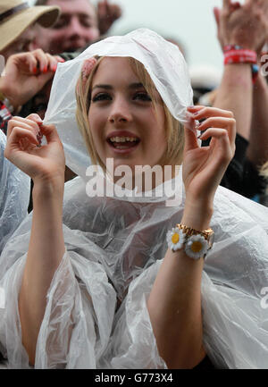 Festival Goer Sara Marshall de Cambridgeshire abris de la pluie au festival de musique T in the Park qui a lieu au parc Balado à Kinross, en Écosse. Banque D'Images