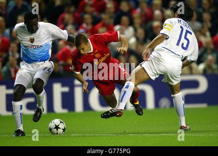 Les Liverpools Milan Baros (au centre) sont envoyés en vol par le FC Basels Murat Yakin (à droite), lors de leur match du groupe F de la Ligue des Champions au stade Anfield de Liverpool. Banque D'Images