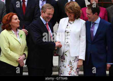 Taoiseach, Enda Kenny, se met en contact avec Tanaiste Joan Burton, ainsi qu'avec les ministres d'État récemment annoncés Kathleen Lynch (à gauche) et Sean Sherlock (à droite) lors d'une séance de photo à l'hôtel Government Buildings, à Dublin. Banque D'Images