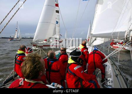 Glasgow Clipper navigue à travers la flotte avant le début de la Clipper 2002 Round the World Yacht Race à l'Albert Dock de Liverpool. La première étape de la course de 11 mois a été reportée de 24 heures en raison de vents forts laissant les huit bateaux identiques assis port avant de courir à Cascais au Portugal. De là, ils continueront sur Cuba, Hawaï, Hong Kong, Maurice et New York. Les équipages sont composés de marins amateurs qui ont subi un programme d'entraînement de rigore pour participer à la course la plus longue du monde. Banque D'Images