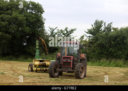 Cas des tracteurs agricoles et un John Deere machine près de Sandford à Somerset, Angleterre, Royaume-Uni, juin 2016 Banque D'Images