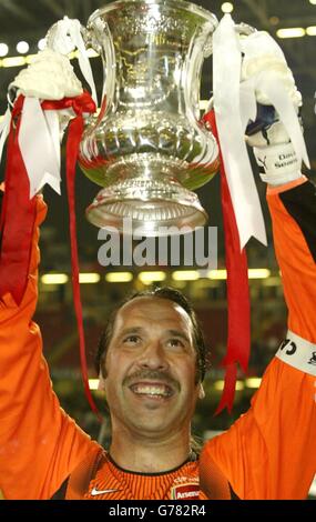 David Seaman d'Arsenal avec la coupe FA après la victoire de ses côtés en 1-0 sur Southampton lors de la finale de la coupe FA au Millennium Stadium de Cardiff. *13/01/04: L'actuel gardien de but de Manchester City a annoncé sa retraite du jeu, suite à une blessure à l'épaule soutenue dans le match de samedi dernier avec Portsmouth. Le matelot de ville est préféré pour succéder au West Ham et au gardien d'Angleterre David James. Banque D'Images