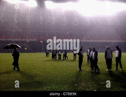 Sir Bobby Robson, gérant de Newcastle United (laissé sous parapluie), inspecte les conditions du terrain avec ses joueurs avant leur match du 2e tour de la Ligue des Champions contre Barcelone en Espagne, qui a été reporté. Banque D'Images