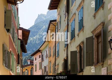 Vue sur la vieille ruelle pittoresque dans la ville de Riva del Garda, avec mountain top au-delà. Banque D'Images