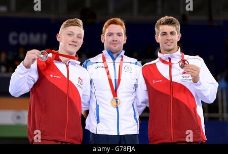 (De gauche à droite) médaillé d'argent de l'Angleterre Nile Wilson, médaillé d'or de l'Écosse Daniel Purvis et médaillé de bronze de l'Angleterre Max Whitlock après la finale des barreaux parallèles masculins, à l'Hydro SSE, lors des Jeux du Commonwealth de 2014 à Glasgow. Banque D'Images