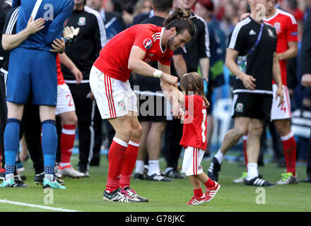 Pays de Galles' Gareth Bale célèbre avec sa fille Alba violet sur le terrain après la ronde de 16 match au Parc des Princes, Paris. Banque D'Images