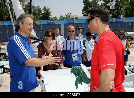 Le Premier ministre Tony Blair (à gauche) et son épouse Cherie (à droite) rencontrent des membres de l'équipe de voile olympique de Grande-Bretagne au Centre olympique de voile d'Agios Kosmas avant le début des Jeux Olympiques d'été d'Athènes en 2004 à Athènes, en Grèce. M. Blair, participant à la cérémonie d'ouverture des Jeux Olympiques dans le cadre d'une tournée, sera sur le plus grand paquebot de croisière au monde, le Queen Mary 2. Il a dit qu'il serait « fantastique » si Londres remporte la course pour les 2012 matchs. Banque D'Images