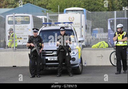 Des officiers de police armés patrouillent dans une porte du village des athlètes alors que la sécurité est renforcée avant les Jeux du Commonwealth de 2014 qui commencent par la cérémonie d'ouverture mercredi soir. Banque D'Images