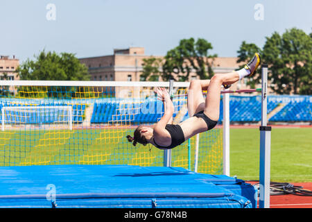 Jeune femme en piste et pelouse,highjump Banque D'Images