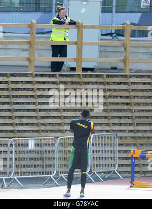 La Jamaïque Usain Bolt prend des photos du personnel de sécurité lors d'une session d'entraînement sur la piste d'échauffement à côté du parc Hampden, pendant les Jeux du Commonwealth de 2014 à Glasgow. Banque D'Images