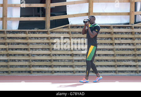 La Jamaïque Usain Bolt prend des photos lors d'une séance d'entraînement sur la piste d'échauffement à côté du parc Hampden, pendant les Jeux du Commonwealth de 2014 à Glasgow. Banque D'Images