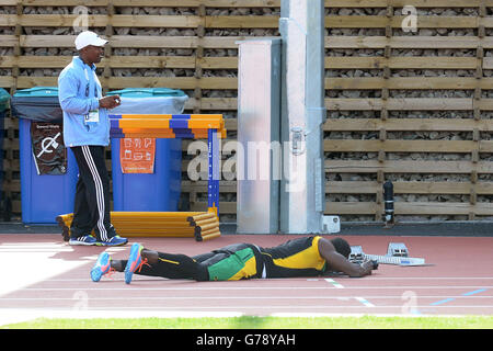 La Jamaïque Usain Bolt prend des photos lors d'une séance d'entraînement sur la piste d'échauffement à côté du parc Hampden, pendant les Jeux du Commonwealth de 2014 à Glasgow. Banque D'Images