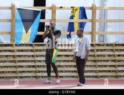 La Jamaïque Usain Bolt prend des photos lors d'une séance d'entraînement sur la piste d'échauffement à côté du parc Hampden, pendant les Jeux du Commonwealth de 2014 à Glasgow. Banque D'Images