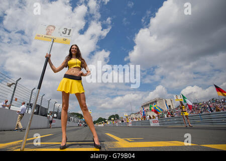 Nuremberg, Allemagne. 26 Juin, 2016. Une grille fille portant le signe pour la pilote de course DTM Tom Blomqvist de RBM-BMW attend l'arrivée des voitures de course à la 8e allemand Tourenwagen Masters (DTM) course sur le norisring à Nuremberg, Allemagne, 26 juin 2016. Photo : DANIEL KARMANN/dpa/Alamy Live News Banque D'Images