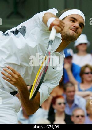 USAGE ÉDITORIAL EXCLUSIF, PAS D'UTILISATION DE TÉLÉPHONE MOBILE.Roger Federer, de Suisse, sert à Mark Philippoussis, d'Australie, lors de la finale masculine aux championnats d'Angleterre de tennis sur gazon à Wimbledon. Banque D'Images