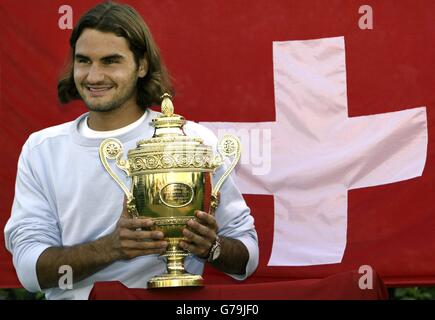 USAGE ÉDITORIAL EXCLUSIF, PAS D'UTILISATION DE TÉLÉPHONE MOBILE Roger Federer de Suisse pose avec le trophée après sa victoire sur Mark Philippoussis d'Australie dans la finale masculine 7:6/6:2/7:6 aux Championnats d'Angleterre de tennis sur gazon à Wimbledon. Banque D'Images