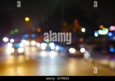 Résumé Les taches de lumière des phares de voiture la nuit et sans organisation floue lumières de rue d'une ville. Banque D'Images