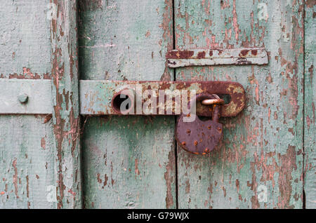 Détail de l'ancienne porte de bois avec un boulon de fer et de vieux cadenas rouillé closeup Banque D'Images