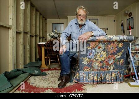 Derrick Bensted, 77 ans, se trouve dans le salon de Stag Cottage, sa maison à Whitstable, dans le Kent. Un mur a été construit au milieu de sa maison après qu'un tribunal a décidé qu'il ne possédait pas la moitié de la propriété. Un tribunal a statué plus tôt cette année que la Whitstable Oyster Fishery Company avait des droits sur la moitié de Stag Cottage, parce qu'elle possédait une section du terrain où elle a été construite. La maison de bord de mer de Derrick Bensted est maintenant sans cuisine, chambre et la plupart du salon après que les constructeurs ont été apportés pour faire appliquer un bail inhabituel datant de l'époque victorienne. Banque D'Images