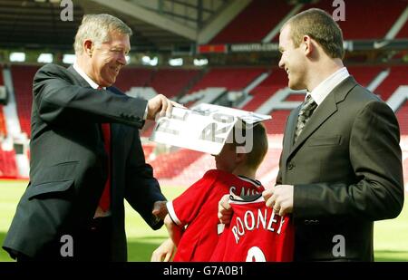 Joe Ruane, fan de Manchester United, 11 ans, partage une blague avec le nouveau Manchester United en signant Wayne Rooney et le directeur Sir Alex Ferguson lors d'une conférence de presse à l'Old Trafford Ground de Manchester United, à Manchester. L'attaquant britannique de 18 ans a terminé son déménagement à United d'Everton dans un marché potentiellement d'une valeur de 27 millions au club de Merseyside juste plus de quatre heures avant la fermeture de la fenêtre de transfert hier. Banque D'Images