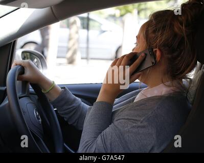 Stock moteur.IMAGE POSÉE PAR UNE FEMME parlant sur son téléphone pendant la conduite. Banque D'Images