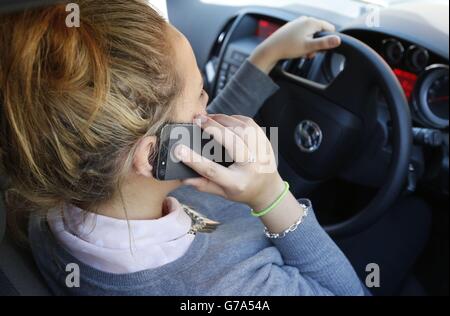 Stock moteur.IMAGE POSÉE PAR UNE FEMME parlant sur son téléphone pendant la conduite. Banque D'Images