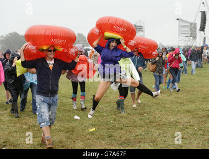 Les festivaliers se réfugiant à l'abri de la pluie pendant la deuxième journée du V Festival, à Hylands Park à Chelmsford, Essex. Banque D'Images