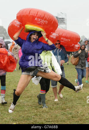 Les festivaliers se réfugiant à l'abri de la pluie pendant la deuxième journée du V Festival, à Hylands Park à Chelmsford, Essex. Banque D'Images