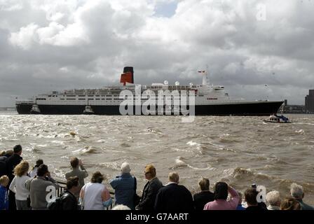 Le paquebot Cunard QE2 descend le Mersey à Liverpool pour lancer la dernière journée du Mathew Street Festival 2004. Les organisateurs affirment qu'il s'agit du plus grand festival de musique libre d'Europe. Banque D'Images