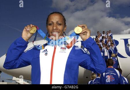 Kelly Holmes, double médaillée d'or, présente ses deux médailles d'or lorsqu'elle arrive à l'aéroport de Gatwick, alors que l'une des équipes olympiques britanniques les plus réussies de l'histoire récente arrive d'Athènes. Banque D'Images