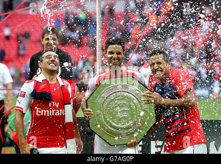 Football - FA Community Shield 2014 - Arsenal / Manchester City - Wembley Stadium.Le Santi Cazorla d'Arsenal (à gauche) Mikel Arteta (au centre) et Alexis Sanchez célèbrent le trophée FA Community Shield Banque D'Images