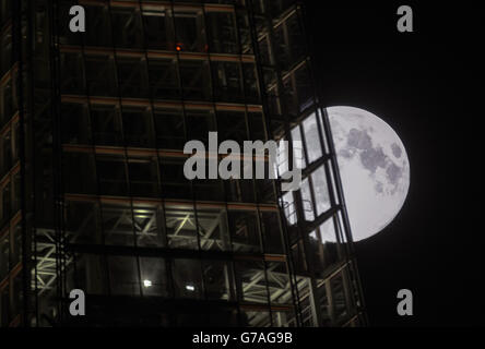 Vue sur la « lune perigée », ou lune perigée, qui s'élève derrière le bâtiment Shard à Londres. Banque D'Images