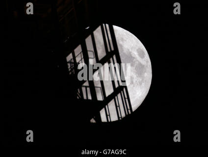 Vue sur la « lune perigée », ou lune perigée, qui s'élève derrière le bâtiment Shard à Londres. Banque D'Images