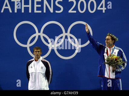 Michael Phelps (à gauche), médaillé d'or américain, regarde le nageur britannique Stephen Parry célèbre après avoir remporté une médaille de bronze au papillon masculin de 200 m au centre aquatique olympique d'Athènes, en Grèce. Banque D'Images