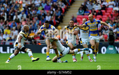 Joel Moon (au centre) de Leeds Rhinos est abordé par Jake Webster (à gauche) de Castleford Tigers et Kirk Dixon (à droite) de Castleford Tigers lors de la finale de la coupe du défi de Tetley au stade Wembley, à Londres. Banque D'Images