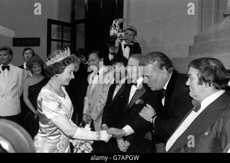 La Reine serre la main avec l'invité surprise de la soirée dernière de la Royal Variety Performance, l'ancien nouvelliste ITN Reginald Bosanquet, qui est apparu dans ce qui était traditionnellement le spot de Dame Gracie Fields, celui de l'introduction de la finale.D'autres, après le spectacle au Théâtre Royal de Drury Lane, sont le comédien les Dawson (r) et (à partir de l-r) Bill Haley, le flûtiste James Galway et Red Buttons. Banque D'Images