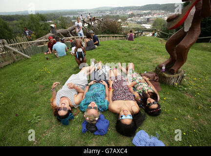 Les amateurs de festival se détendent à un point de vue élevé surplombant le site de Bestival, qui se tient au parc d'attractions Robin Hill, à l'île de Wight. Banque D'Images